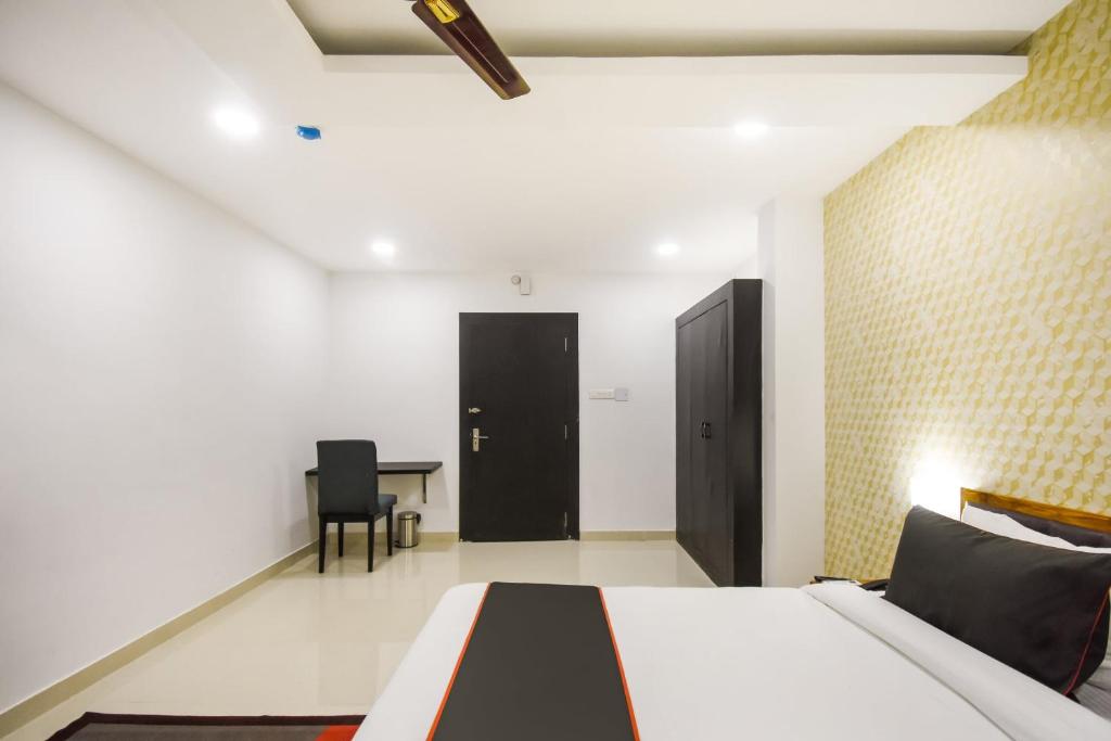 a bedroom with a bed and a table and a door at Hotel O Red Velvet Premium in Bālianta