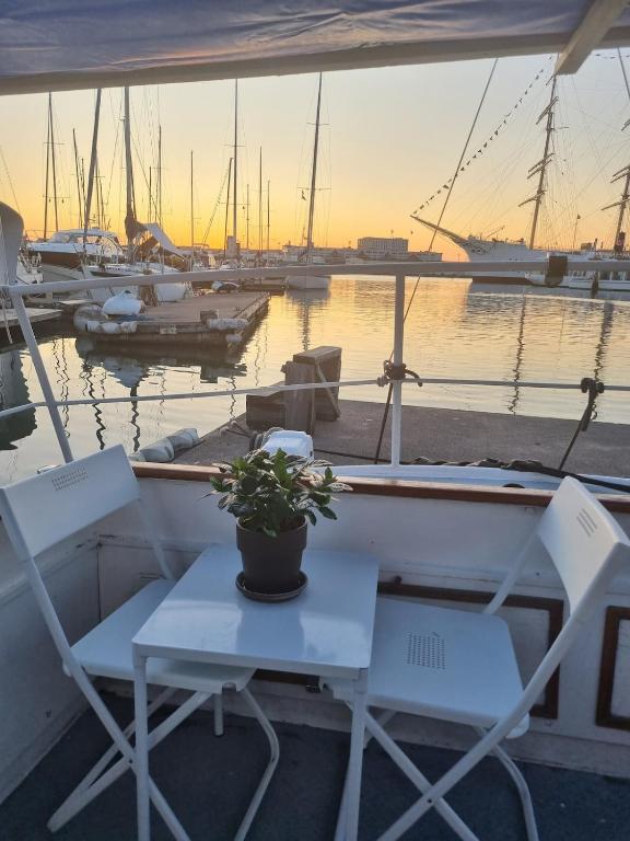 a table and chairs on a boat in a marina at Downtown Boat-Apartment in Gothenburg