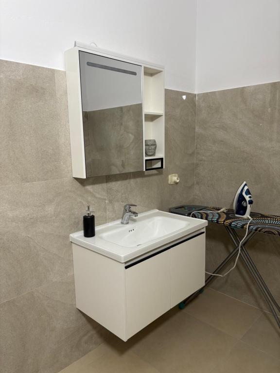 a bathroom with a white sink and a mirror at Marina Oasis Apartments in Vlorë