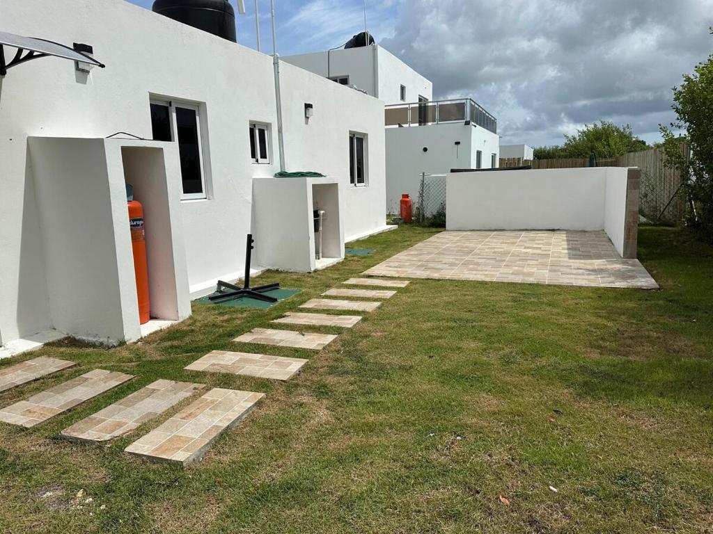 a yard with a white building and a grass at Preciosa villa in Punta Cana