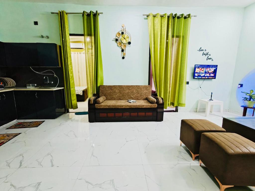sala de estar con cortinas verdes y sofá en Euphoria Stays 2BHK in Dehradun, en Dehradun