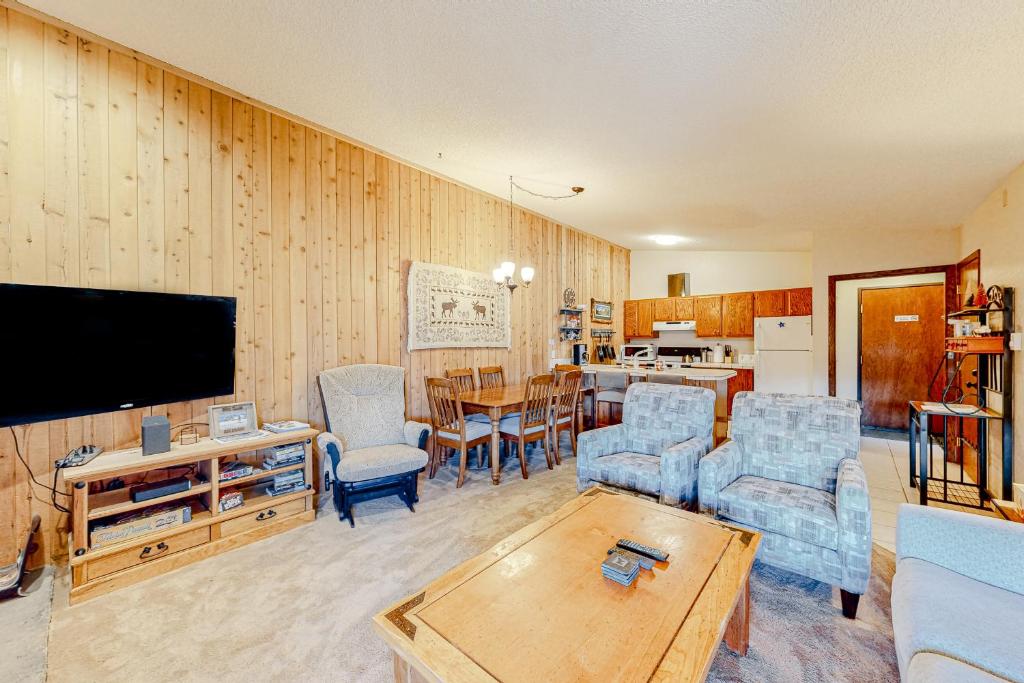 a living room with a tv and chairs and a table at Cozy Corner in Winter Park