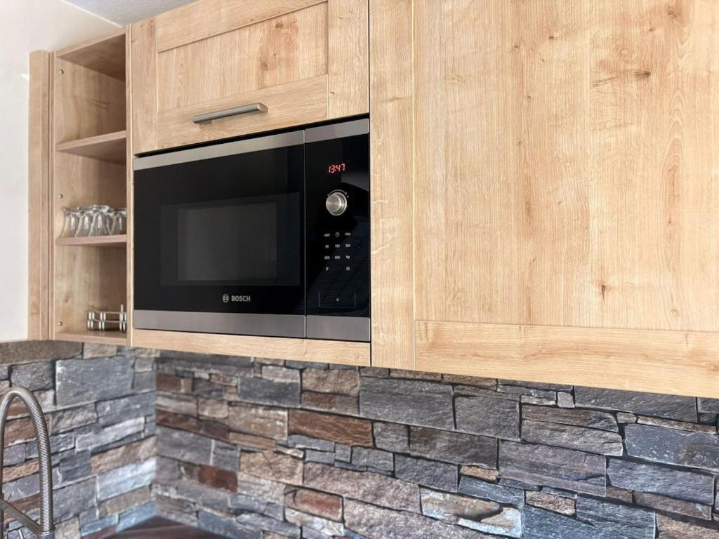 a kitchen with a black microwave in a wooden cabinet at Fewo Goldstück in Willingen
