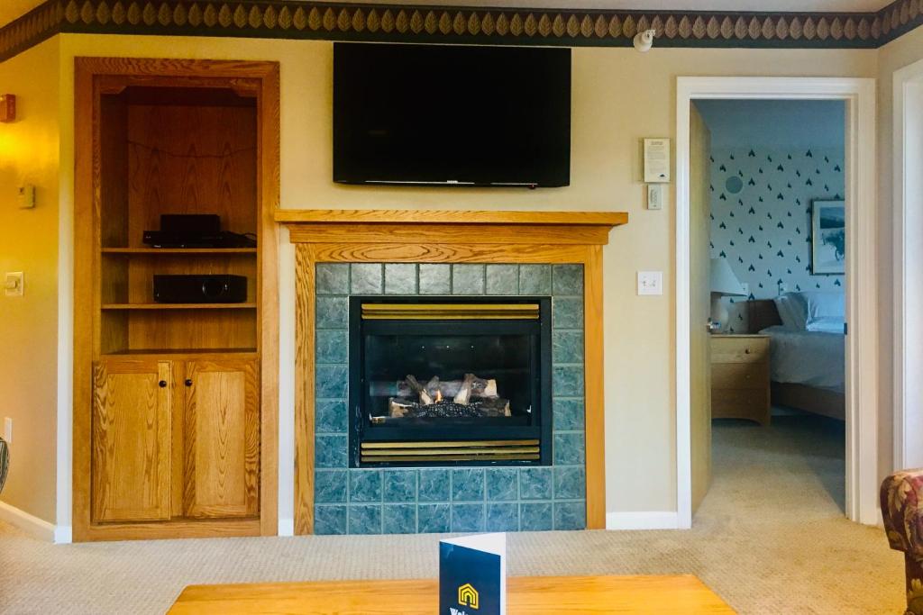 a living room with a fireplace with a tv above it at Trailside Highlands #7 in Morses Mill