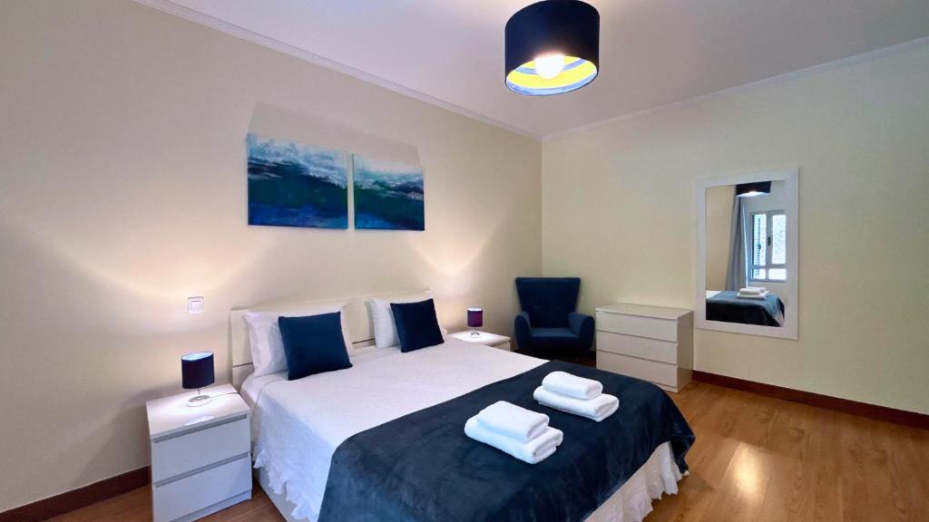 een slaapkamer met een bed met twee handdoeken erop bij Dragoeiro Duplex by Sam Houses in Ribeira Brava