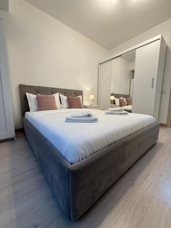 a large bed in a bedroom with a large mirror at Touch and Go Apartment near Bucharest Airport in Otopeni
