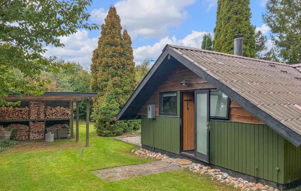 a green cottage with a garage and a yard at 2 Bedroom Gorgeous Home In Græsted in Græsted