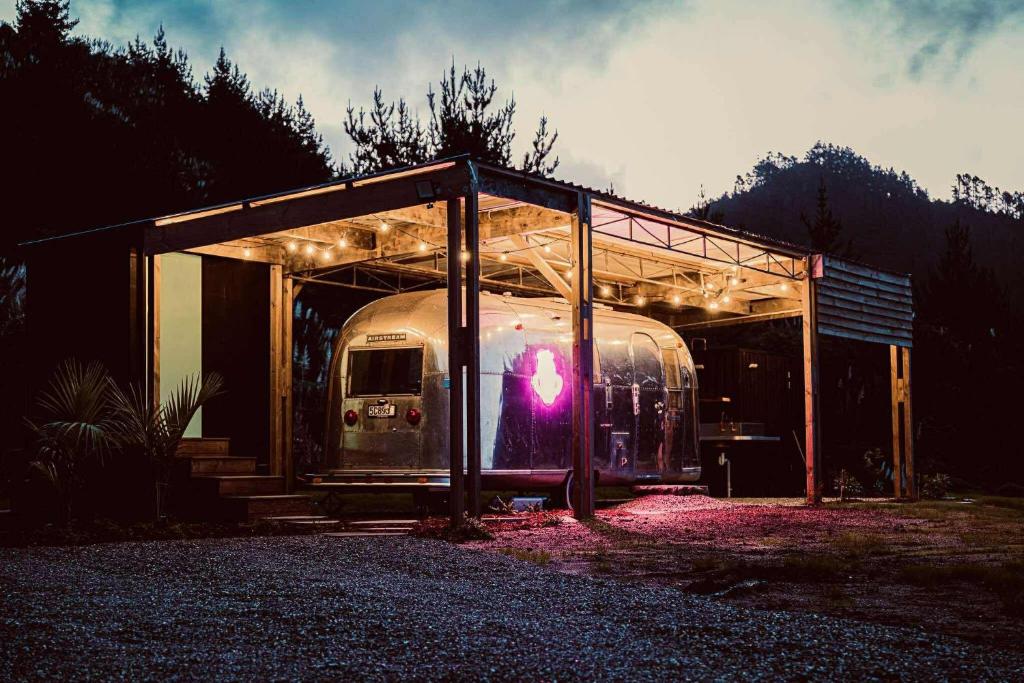 a trailer parked under a building with a roof at Airstream Caravan at Matakana Retreat in Matakana