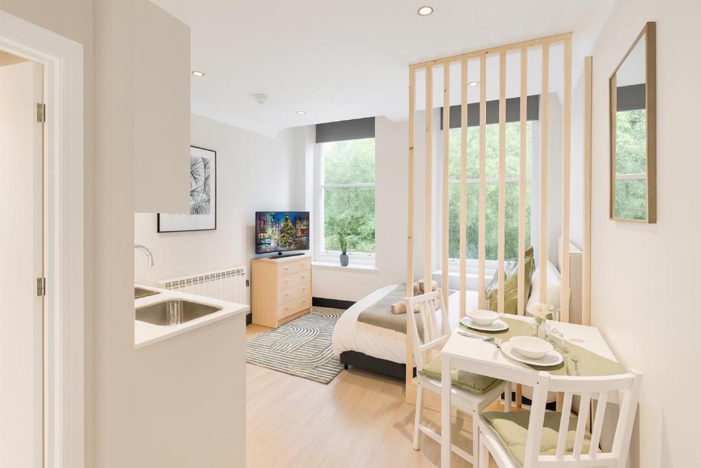 a kitchen and living room with a table and a sink at Royal Oakwood Studio 1 Bed Brighton Sleeps 2 in Brighton & Hove