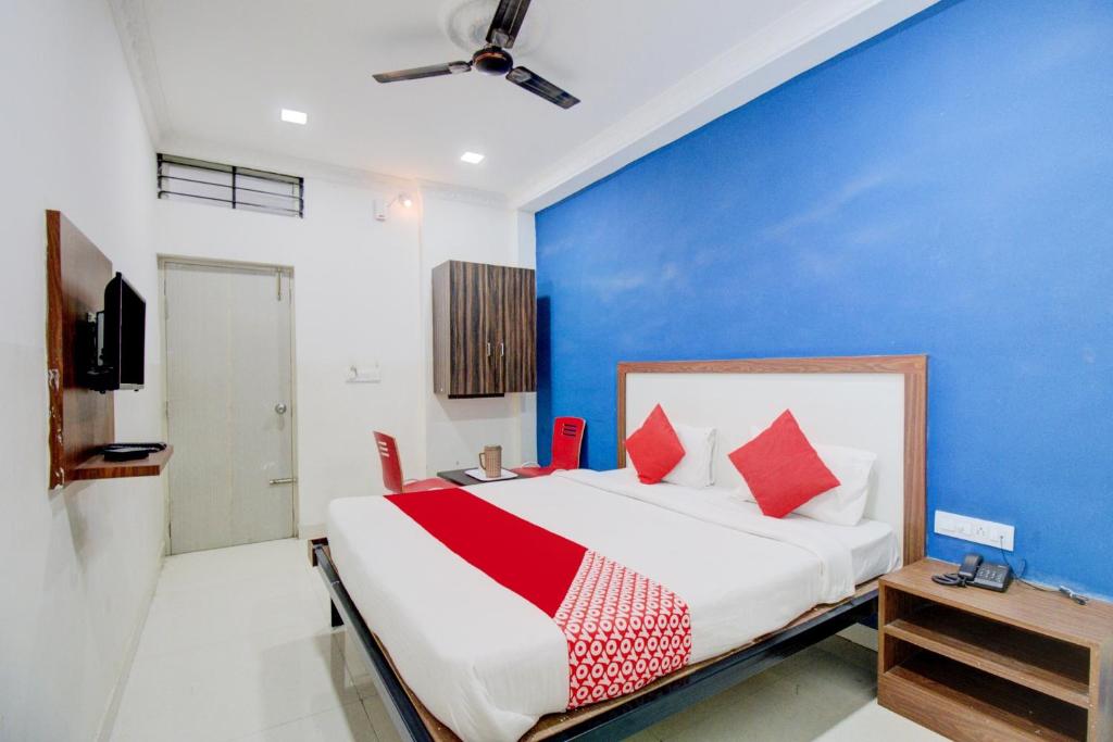 a bedroom with a bed and a blue wall at Hotel O Abhimaani Inn in Bengaluru