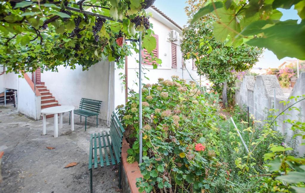 eine grüne Bank in einem Garten neben einem Gebäude in der Unterkunft Amazing Apartment In Santa Maria Di Castell in Santa Maria di Castellabate