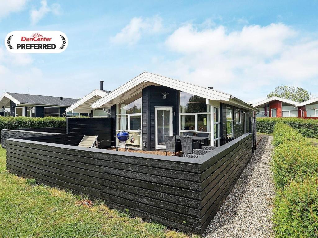 a small house with a large deck in a yard at 6 person holiday home in Tranekær-By Traum in Tranekær