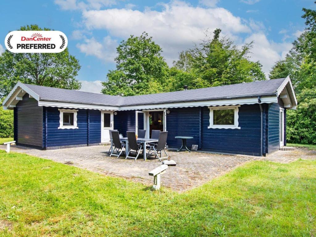 a blue house with a picnic table in front of it at 6 person holiday home in Silkeborg-By Traum in Silkeborg