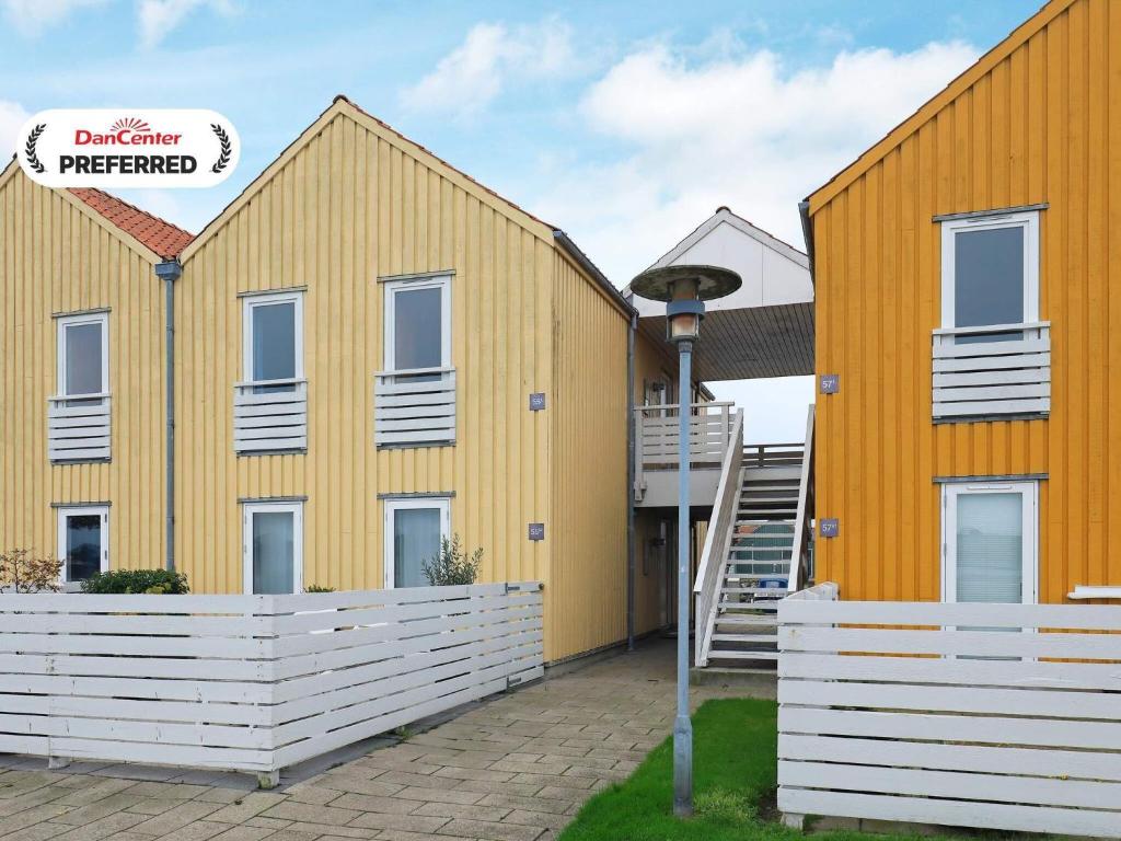 a yellow building with a staircase in front of it at 6 person holiday home in Rudkøbing-By Traum in Rudkøbing