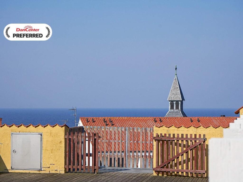 a church with a steeple on top of a building at 4 person holiday home in Gudhjem-By Traum in Gudhjem