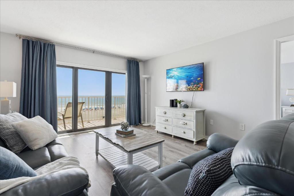 un salon avec un canapé et une table dans l'établissement Boardwalk 401, à Cocoa Beach