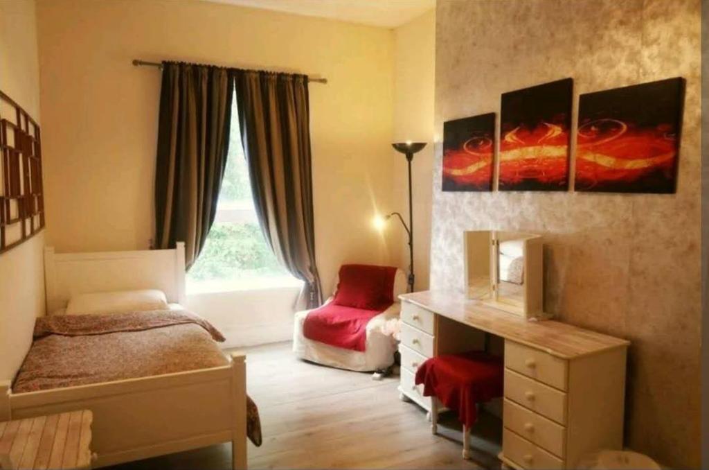 a bedroom with a bed and a desk and a window at Home-stay Cambridge in Cambridge