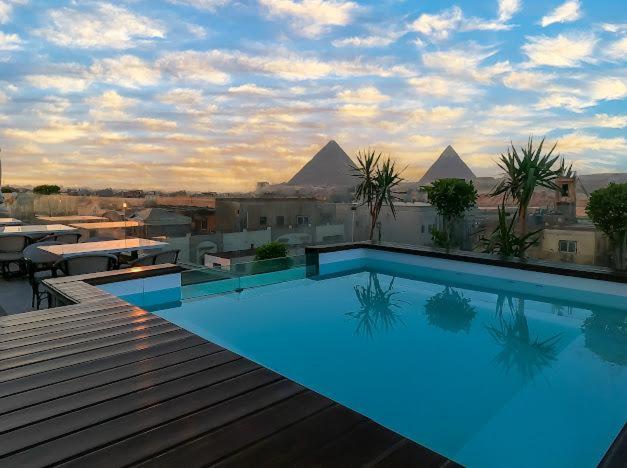 a swimming pool with a view of the pyramids at Pyramids Gem Plaza Hotel in Cairo