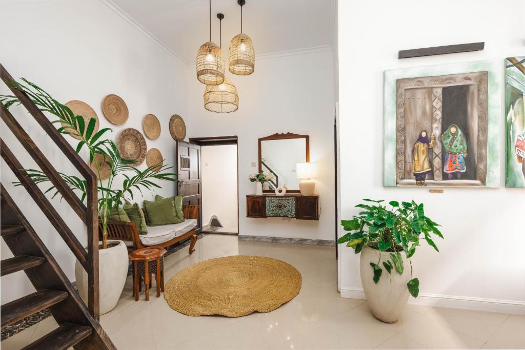 Una sala de estar llena de muchas plantas y una escalera. en Bait Al Bagh Zanzibar Stone Town by Liv Zanzibar, en Ngambo