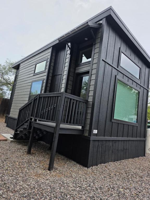 a black tiny house with a large deck at Turquoise Triangle in Cottonwood