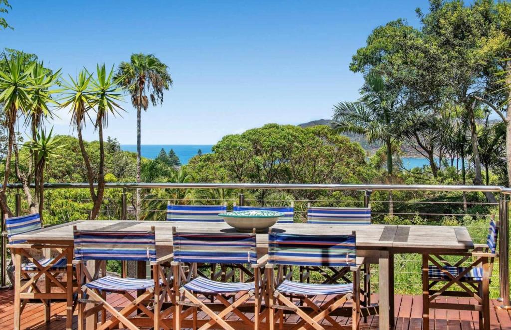 a table and chairs on a deck with a view of the ocean at Paraiso Del Mar - by Coast Hosting in Copacabana