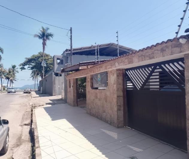 a brick building with a garage on the side of a street at Beach Milionario in Guarujá