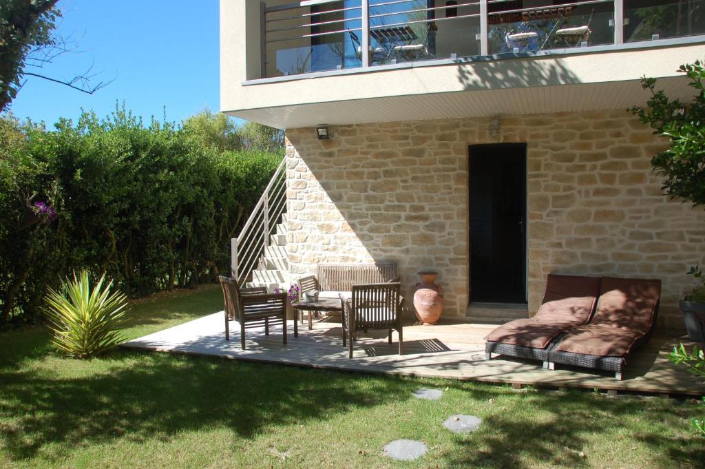 une terrasse avec une table et des chaises devant une maison dans l'établissement L'Alidade Chambres d'hôtes, à Wimereux