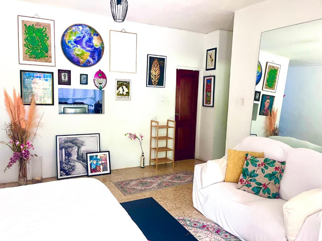 a living room with a white couch and pictures on the wall at City Siesta in Kingston