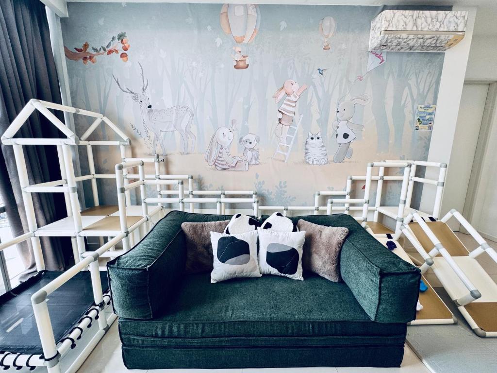 a room with two bunk beds and a green couch at Azure Residences, PJ Paradigm By Kiddie Space, Kids Friendly in Petaling Jaya