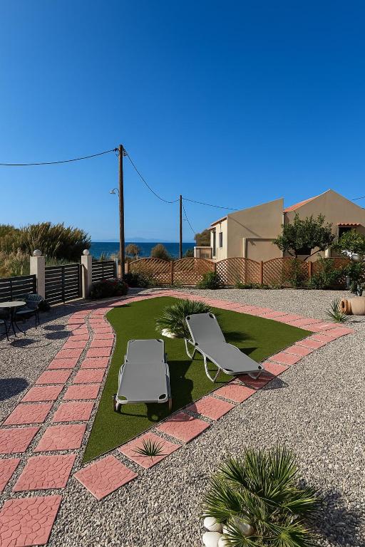 a patio with two lawn chairs and the ocean at Blue waves house 1 in Rhodes Town