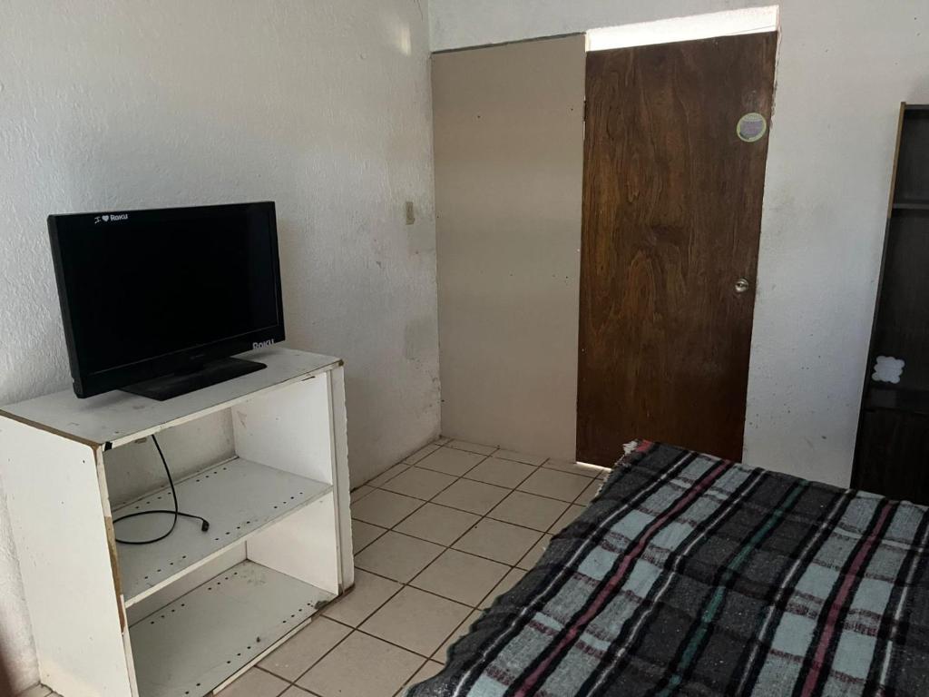 ein Zimmer mit einem Fernseher auf einem Tisch mit einem Bett in der Unterkunft La casa del buen paso in San Lorenzo