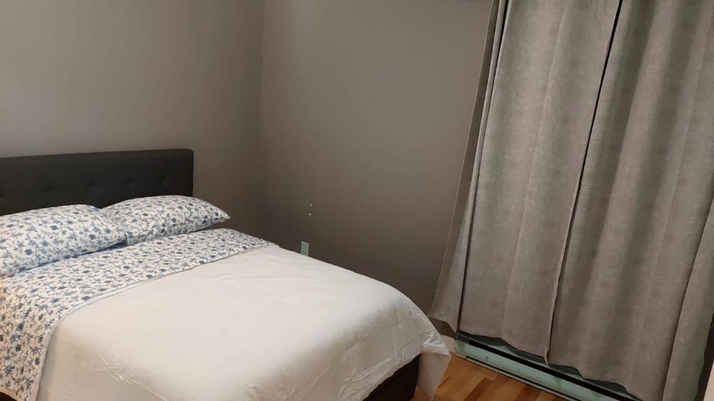 a bedroom with a bed and a window at Spacious and comfortable accommodation in Longueuil