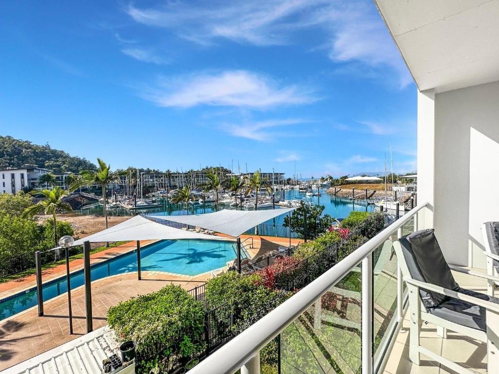 a balcony with a view of a pool at Beachside 17 in Nelly Bay
