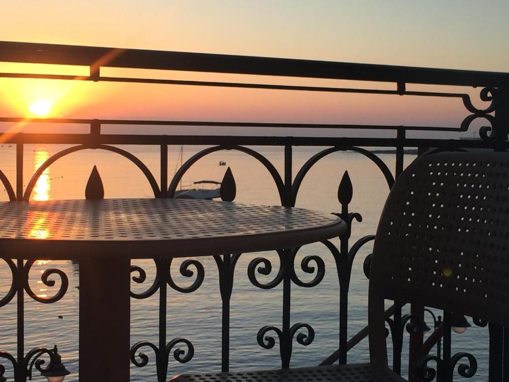 stół i krzesła na balkonie z widokiem na zachód słońca w obiekcie Maltese Balcony w mieście St. Julian’s