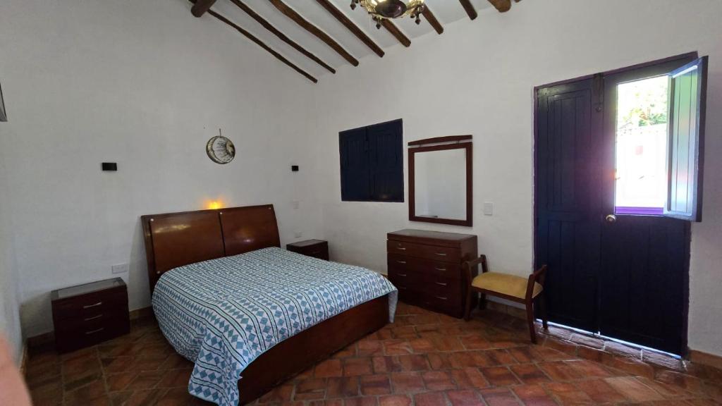 una camera da letto con un letto, uno specchio e una finestra di IL CASTELLO DI LETTERE Barichara a Barichara