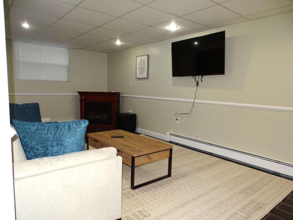 a living room with a couch and a flat screen tv at Comfortable Renovated 3 Bed Apartment in Framingham