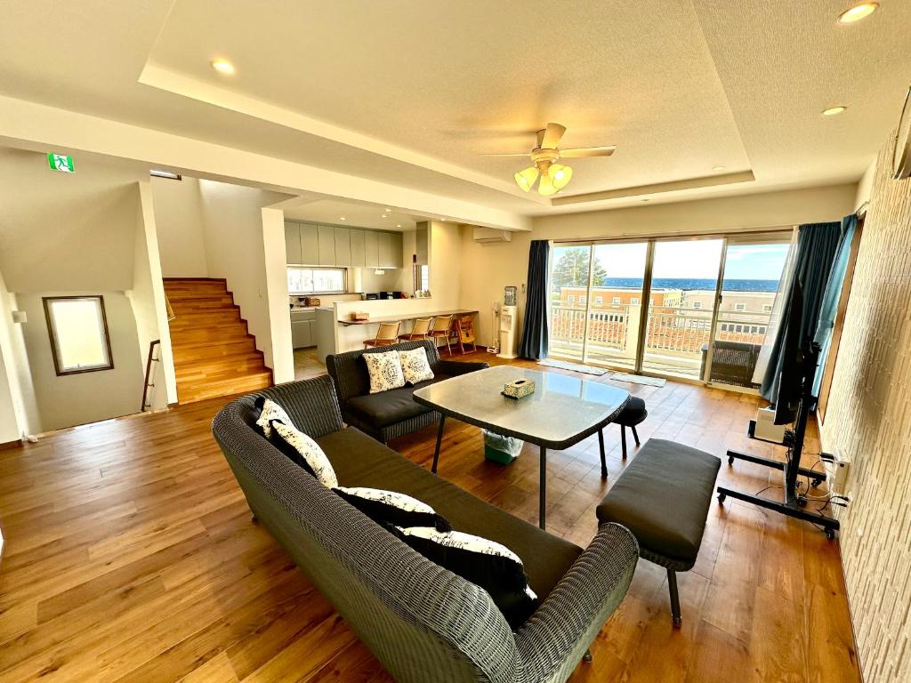 a living room with a couch and a table at Beach house Yomitan 都屋別館 in Yomitan