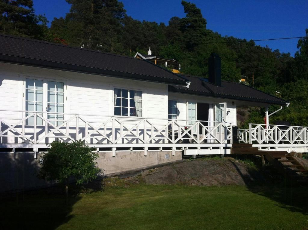 una casa blanca con una valla blanca delante en Sjøutsikt Og Skogsro På Rødtangen, en Berger