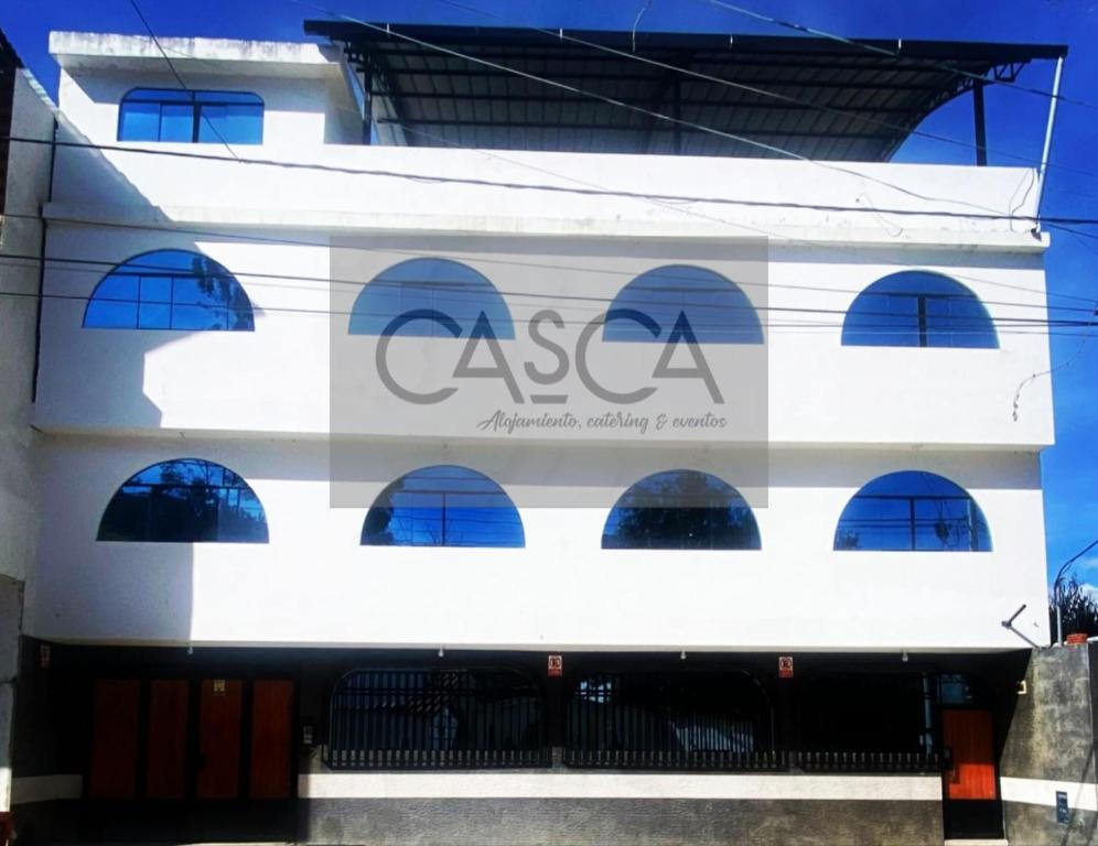 a white building with a sign on the side of it at Alojamiento Casca in Huaraz
