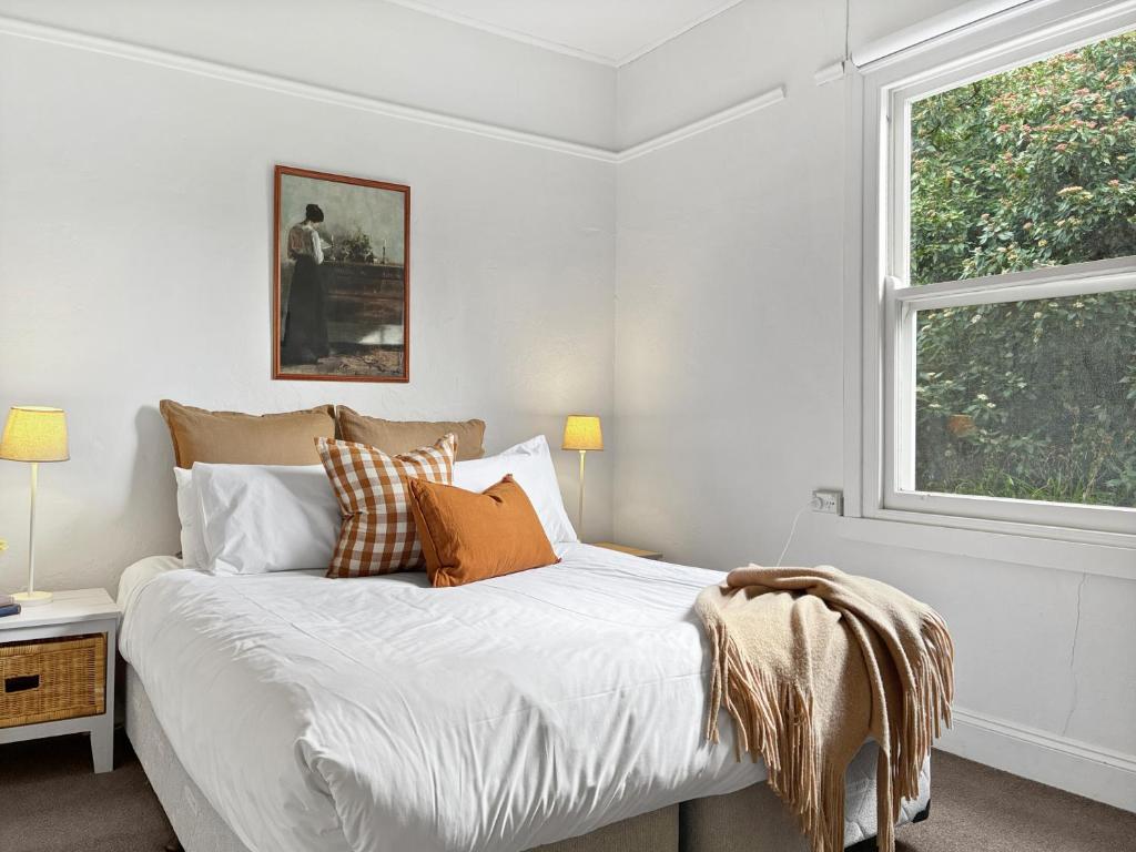 ein weißes Schlafzimmer mit einem Bett und einem Fenster in der Unterkunft Dawns Cottage in the heart of Daylesford with Fireplace in Daylesford