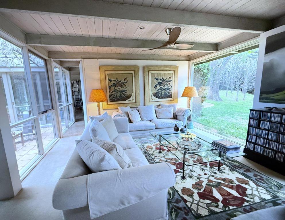 a living room with white couches and a tv at Foxwood - Romantic French Style Country Retreat in Foxground