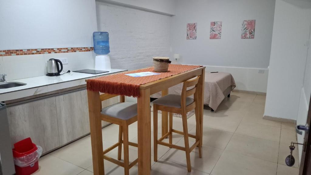 a small kitchen with a table and two stools at Complejo Los Azahares in Presidencia Roque Sáenz Peña