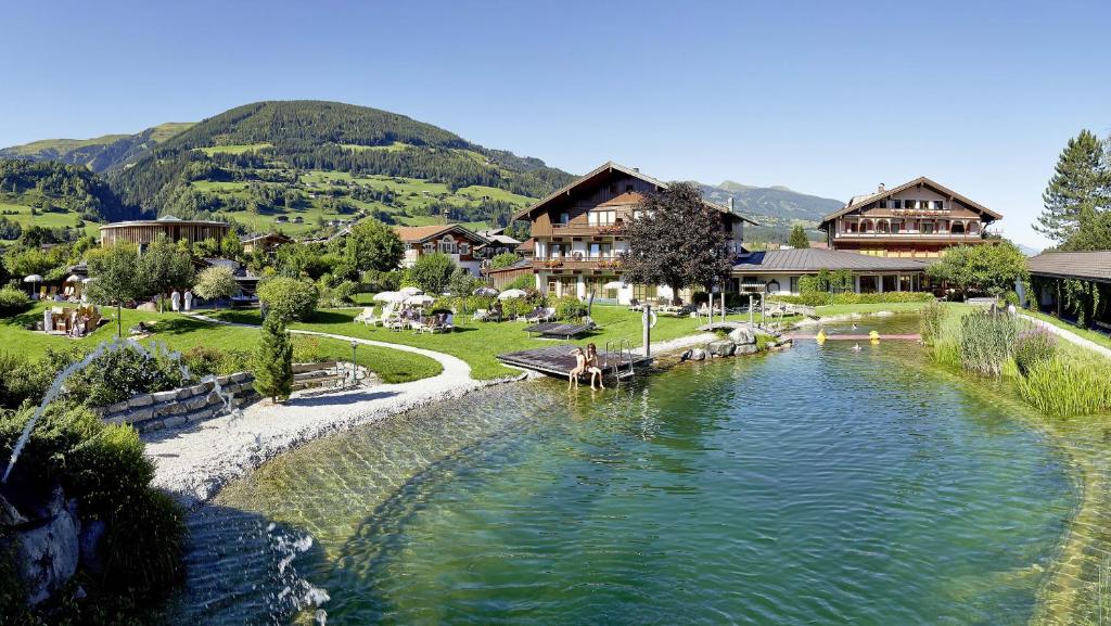 einen Fluss vor einem Dorf mit Häusern in der Unterkunft Wanderhotel Kirchner in Bramberg am Wildkogel