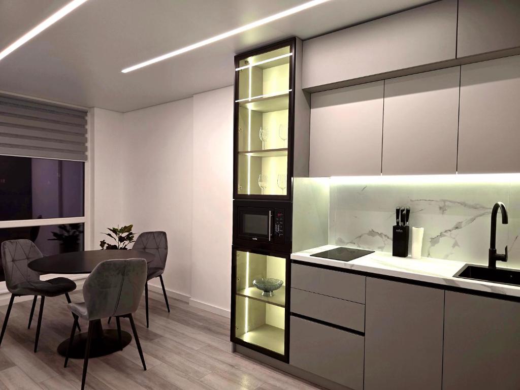 a kitchen with a table and a dining room at Belvedere Apart 2, parking in Ivano-Frankivsʼk