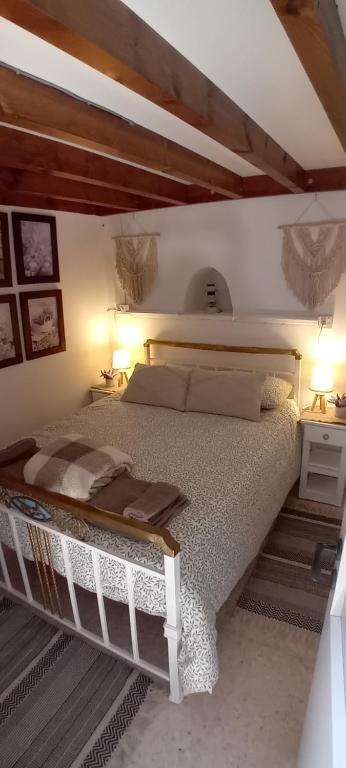 a bedroom with a large bed with two lamps and two tables at En Sylikion cottage in Silikou