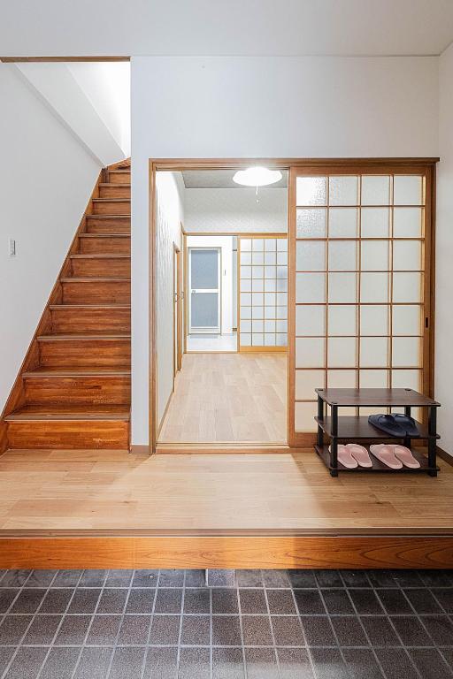 a room with a staircase with a bench and a door at 勝清居 大阪獨棟車庫民宿 千日前線新深江站2分一線直達 難波日本橋 全新裝修3LDk in Osaka