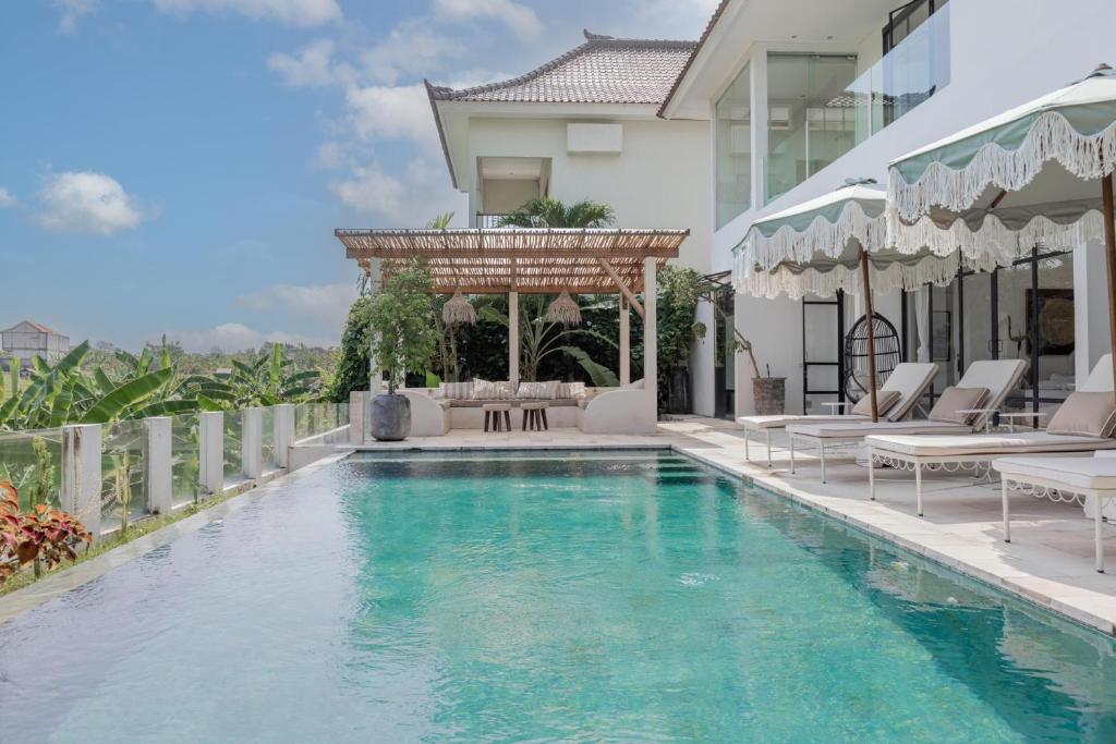 a swimming pool with a gazebo next to a house at BI Design House Canggu in Canggu