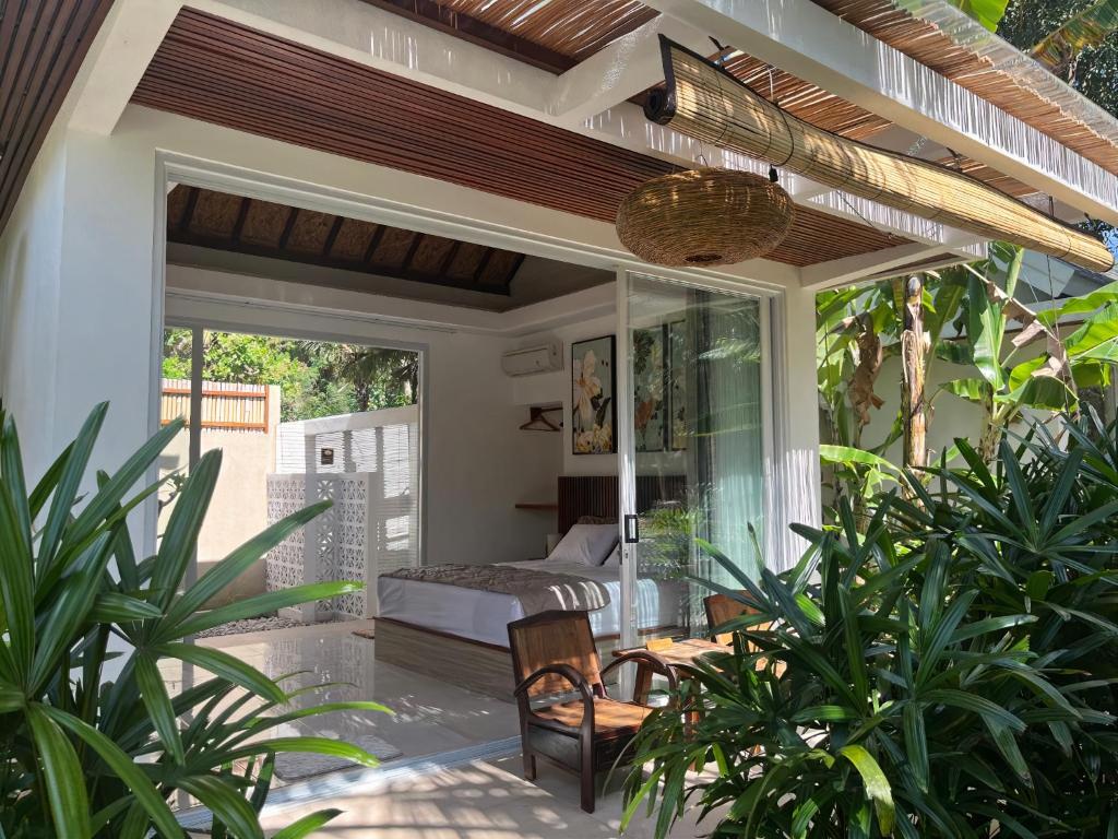 een patio met een bed en een kamer met planten bij Udãra Hideaway Villa in Toyapakeh