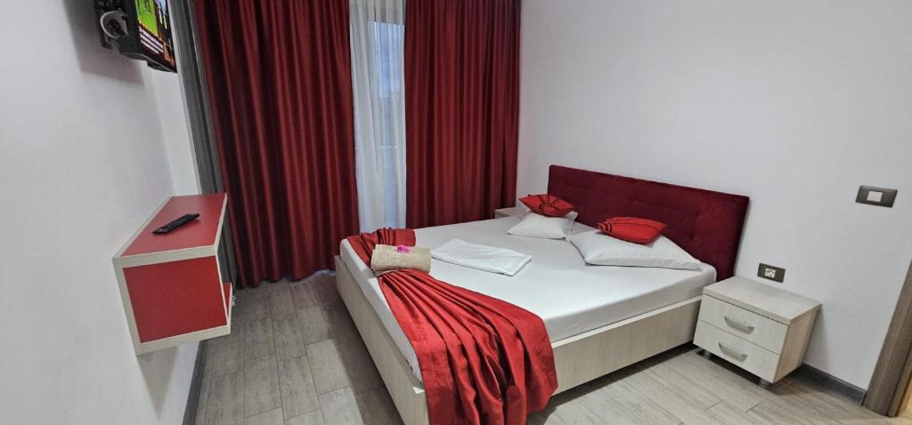 a bedroom with a bed with a red blanket on it at Luxury Apartment in Alezzi Resort Piscina Interioara & Spa in Mamaia Nord