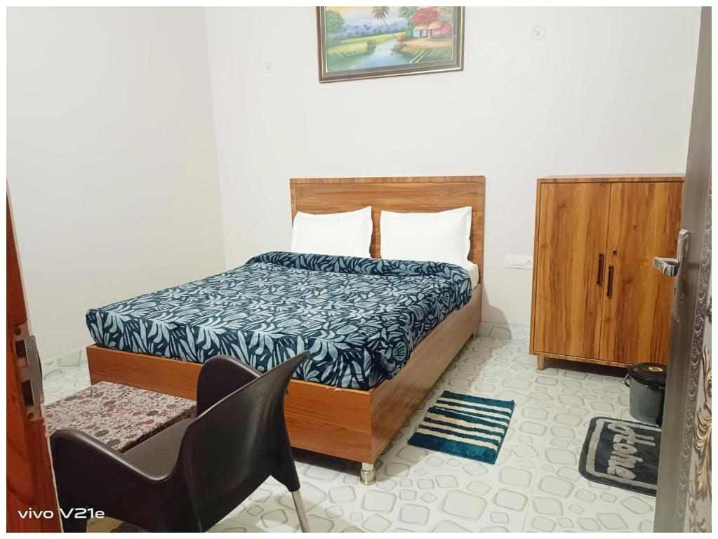 a bedroom with a bed and a chair in it at Hotel !! Anand - Palace Near Banaras Railway Station - Offers Budget Rooms With Wi-fi Facility - A Comfort Stay Guest House In Varanasi in Varanasi